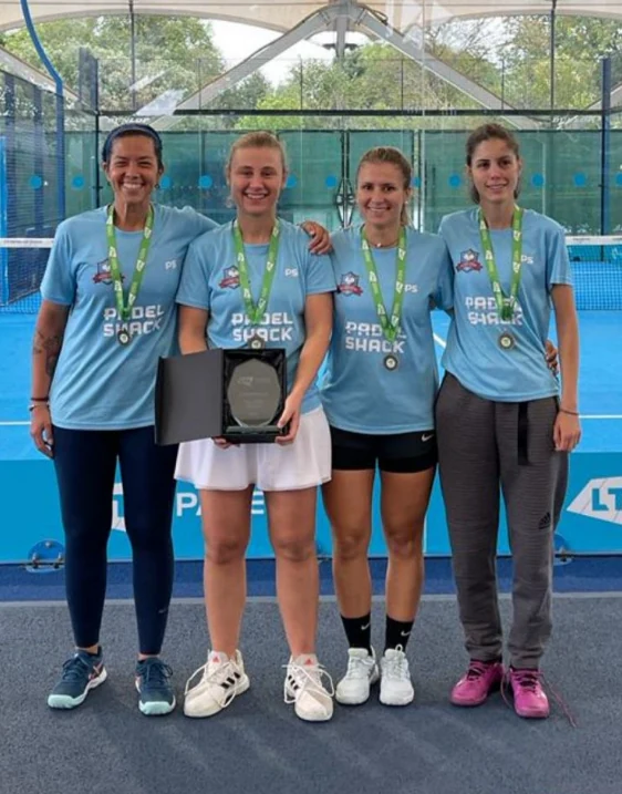 Four padel players wearing medals and posing together